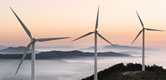 Image:  Three wind turbines on a mountain top at dawn